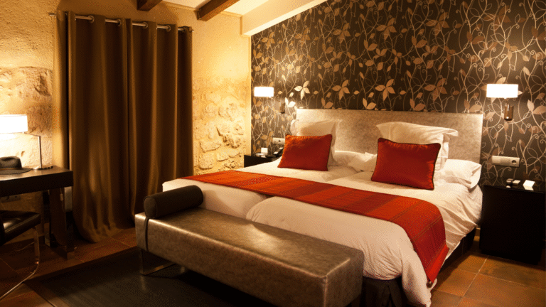 Luxuriöses Schlafzimmer mit ordentlich gemachtem Bett aus hochwertiger Baumwollbettwäsche, warmem Licht und elegantem Dekor.