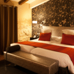 Luxury bedroom with neatly made bed dressed in high-quality cotton bedding, warm lighting and elegant decor.