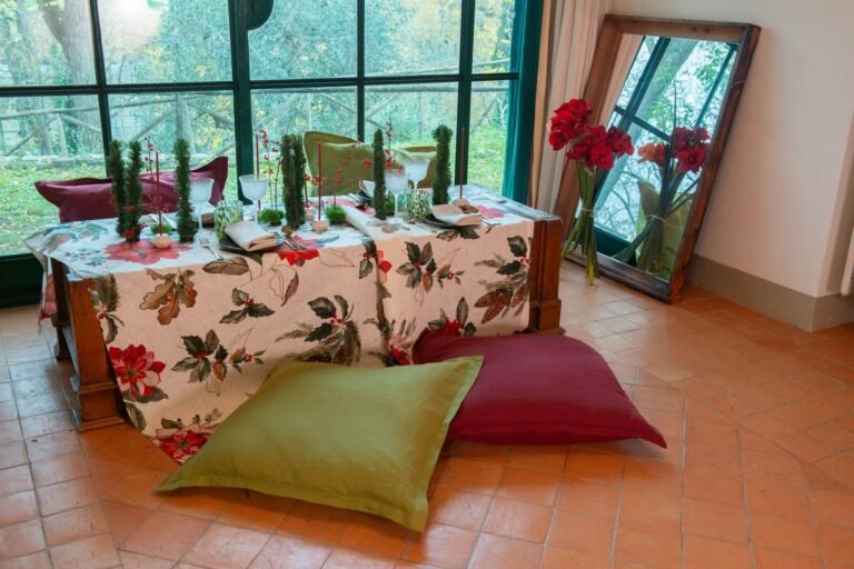 Long Christmas table set with the Etoile printed linen tablecloth, red poinsettias and holly on white linen