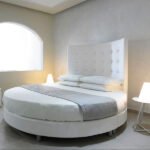 Elegant circular bed sheets on a round bed in a cozy modern interior, featuring luxurious design and sun lighting